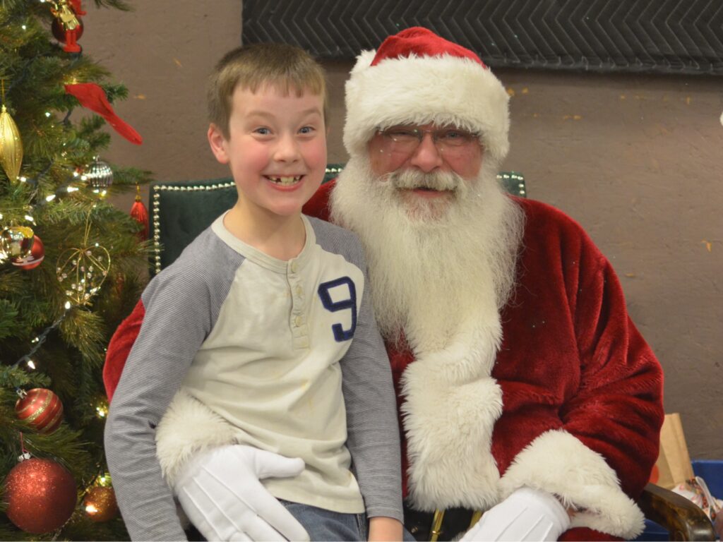 Young boy and Santa Tom smiling for the camera