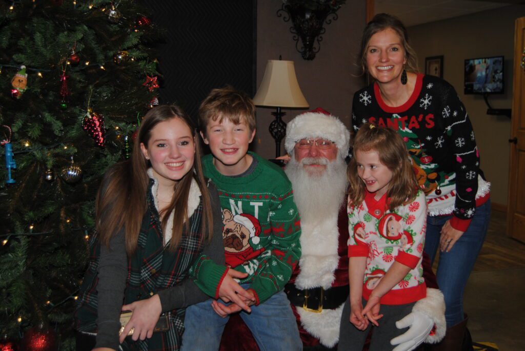 Santa Tom poses with a family at a Central Missouri Christmas Event
