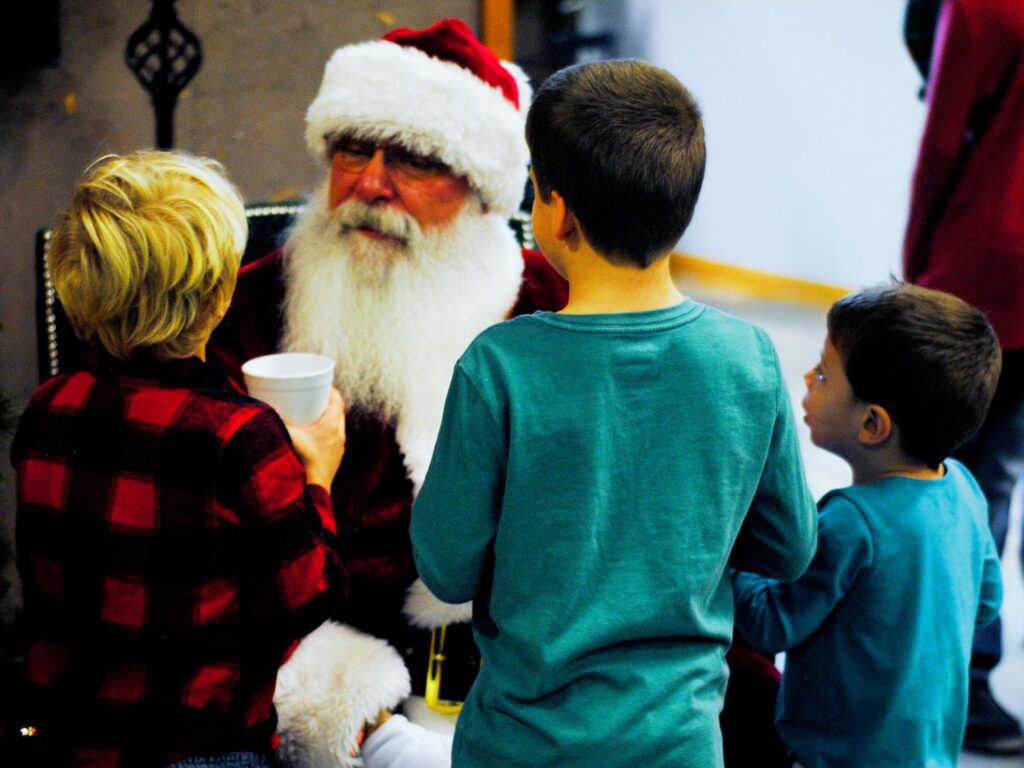 Santa Tom listening to a group of boys at a Central Missouri Christmas event