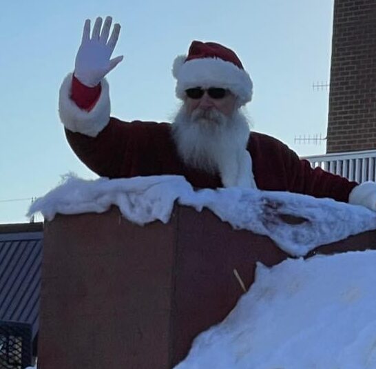 Santa Tom waving from chimney of a float in the Auxvasse Christmas parade