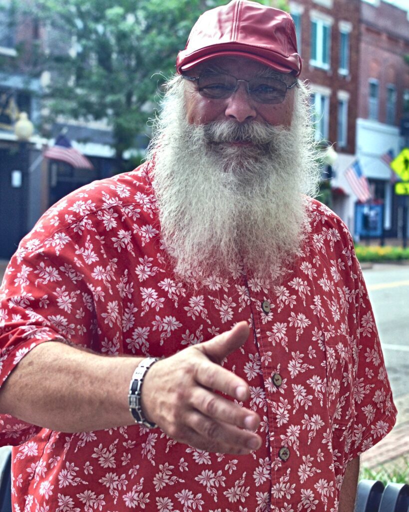 Santa Tom smiling and reaching out for a friendly greeting in downtown Jefferson City, Missouri.