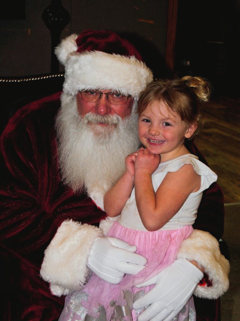 Santa Tom posing for a family-friendly Christmas photo moment