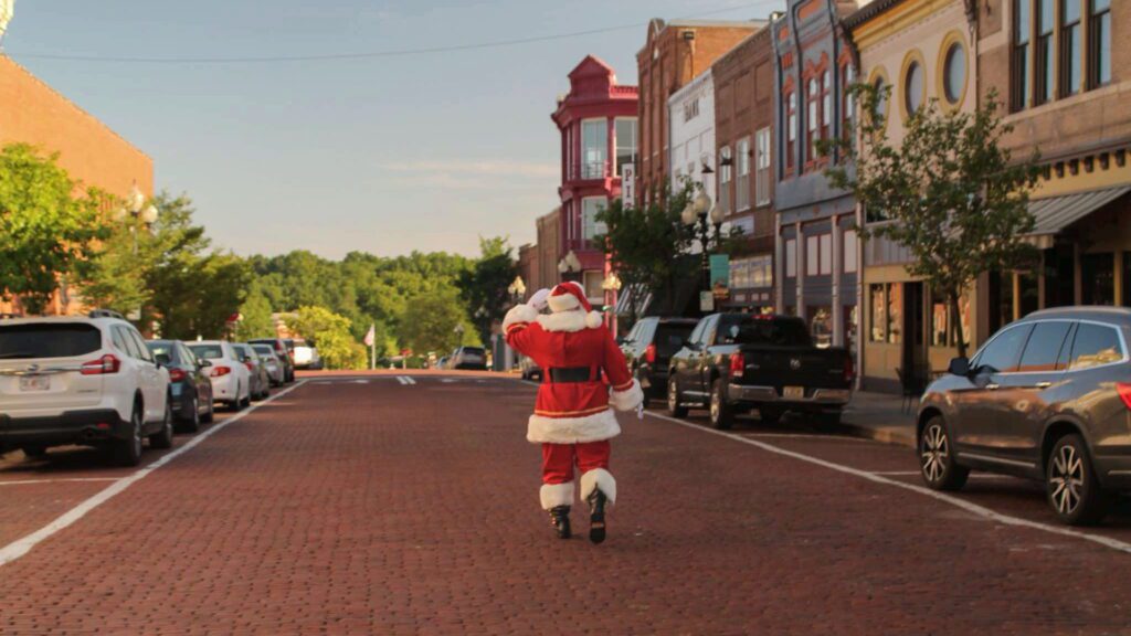 Santa Tom walking along a brick street in downtown Fulton, Missouri.